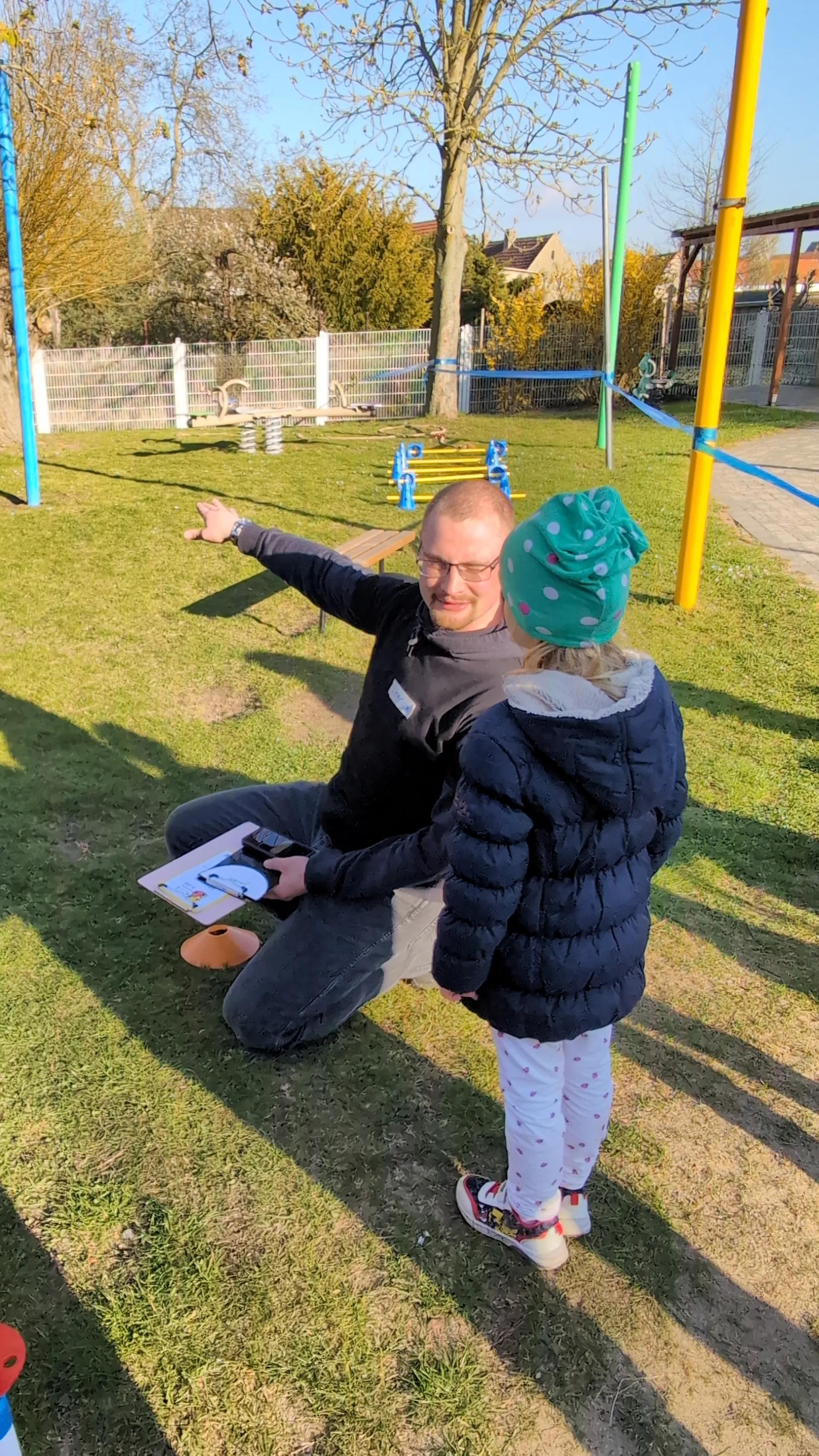 Kinderanimateur Lennox erklärt einem Kind den Parcours der Erlebnisinsel.