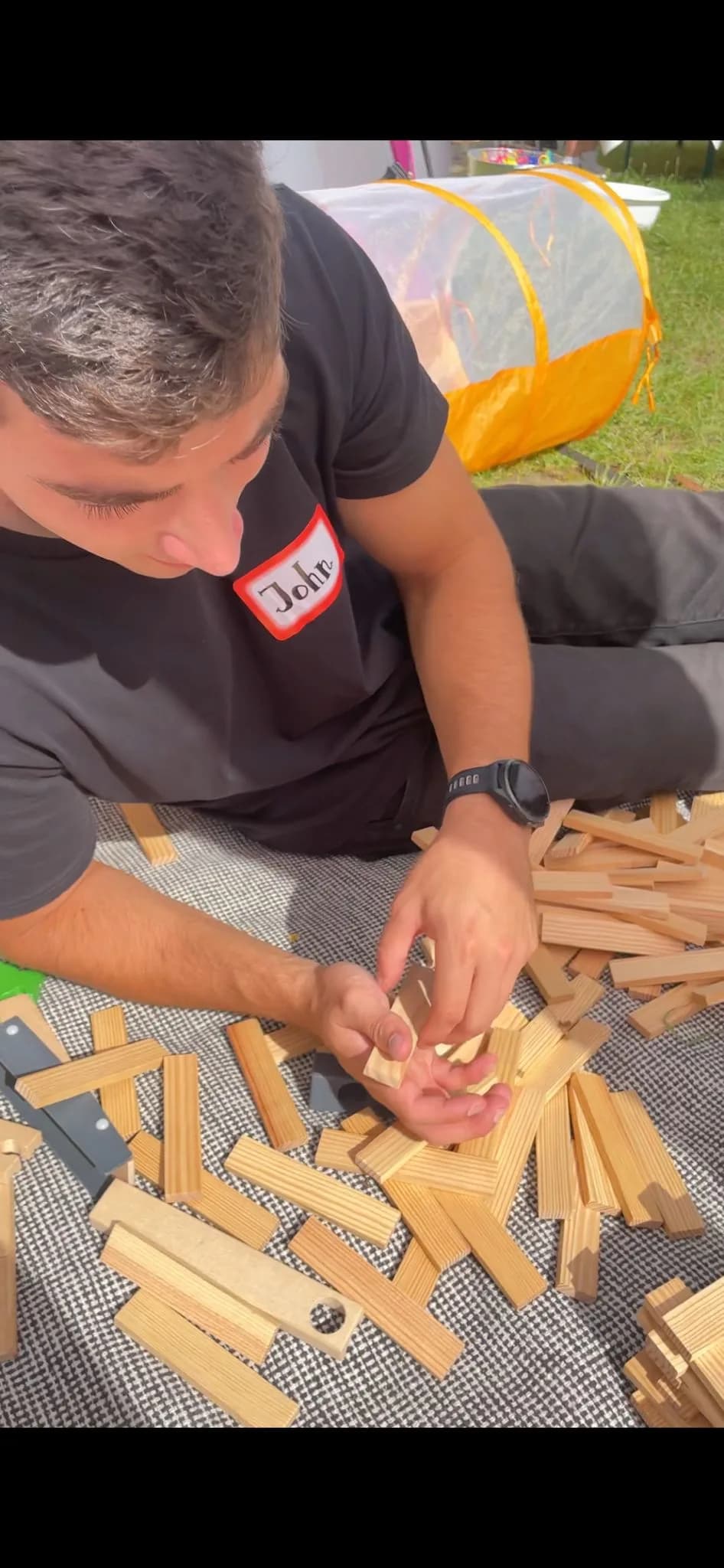 Mitarbeiter John der Erlebnisinsel beim kreativen Spiel mit Holzbausteinen